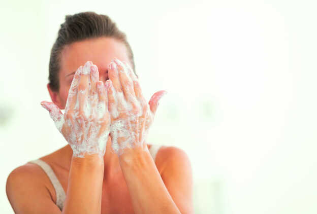 Chica lavándose la cara/Fotolia