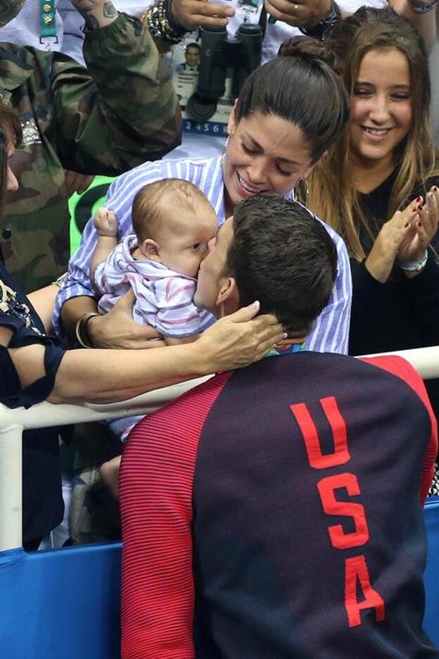 Michael Phelps se acerca a la grada para dar un beso a su hijo de tres meses./getty.