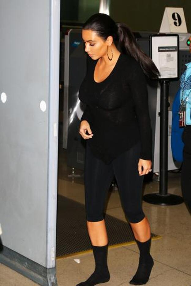 Kim Kardashian pasando el control de seguridad en el aeropuerto con ropa cómoda.