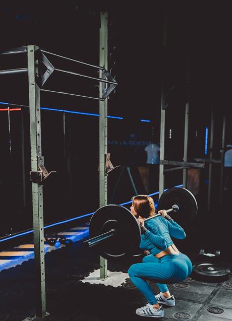 Mujer haciendo sentadillas/PEXELS