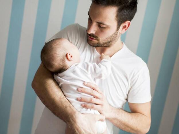 Un hombre junto a su hijo recién nacido/fotolia