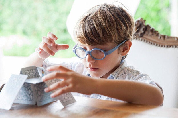 Niño concentrado con las cartas de naipe./Gtres