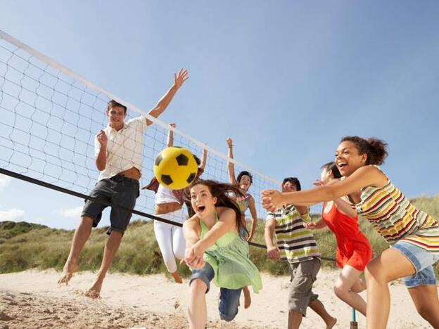 Adolescentes jugando a volley playa/ADOBE STOCK