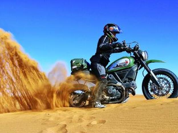 Alicia sacando su moto en una duna en Marruecos.