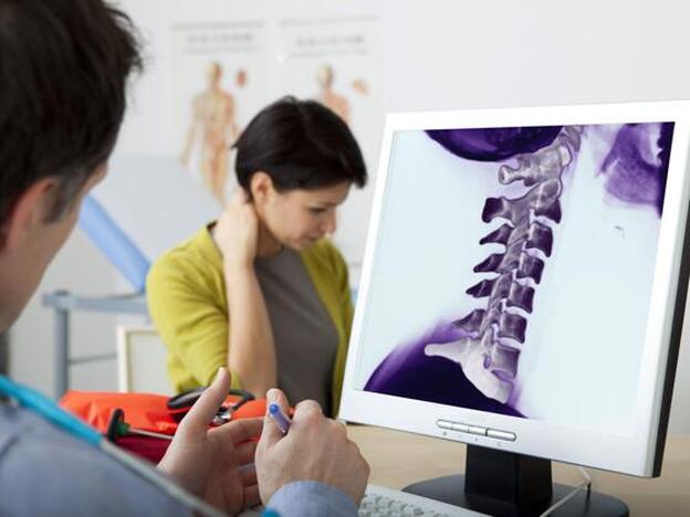 Un doctor examinando un esguince cervical./Getty