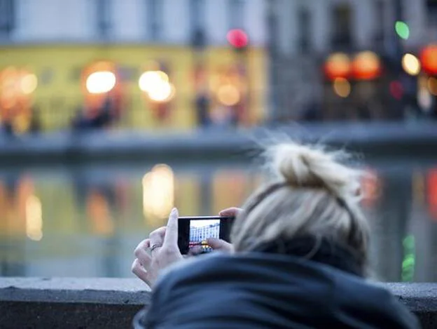 Una mujer, haciendo una foto con el móvil./GTRES