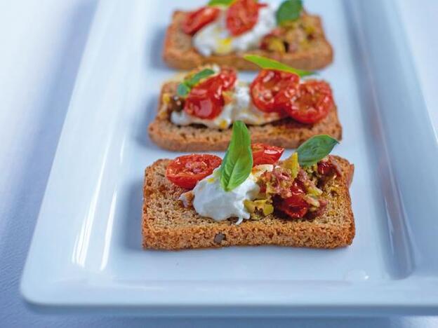 Tostas de pan de centeno con burrata y tomate seco.