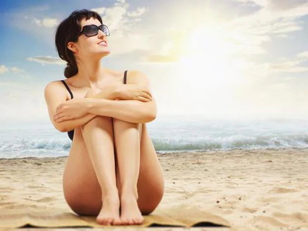 Una mujer toma el sol en una playa./pixabay