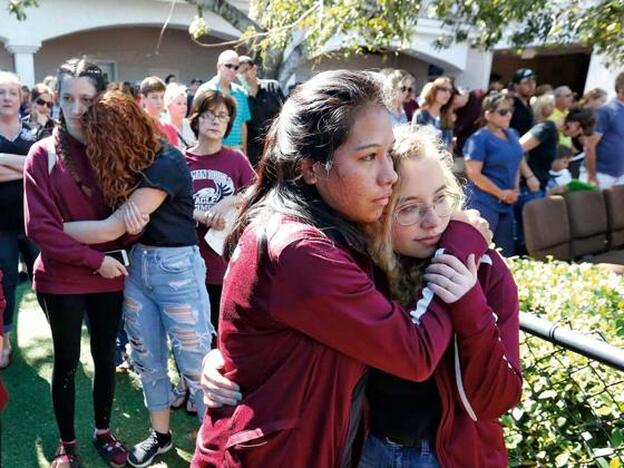 Dos estudiantes se consuelan en la vigilia por los 17 muertos en la escuela secundaria Marjory Stoneman Douglas de Florida, en febrero de este año.