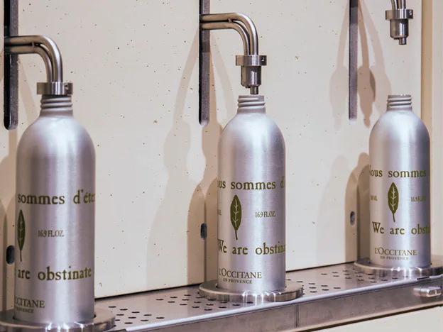 Fuente de L’Occitane para rellenar botellas de aluminio con gel de ducha y jabón de manos.