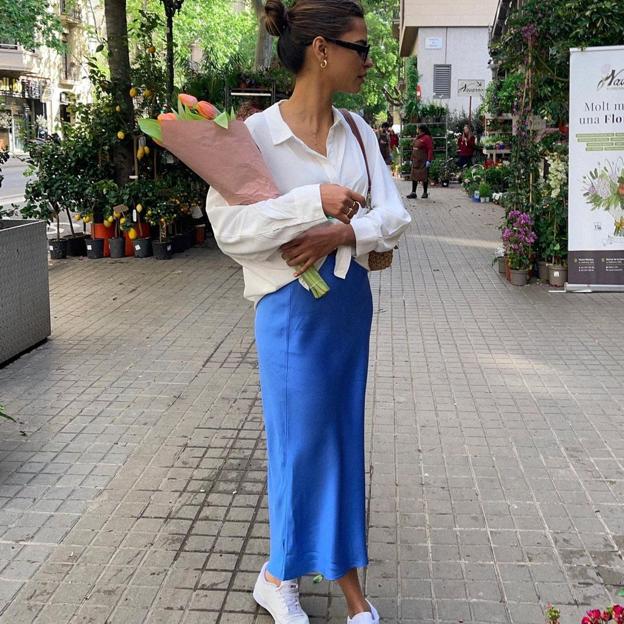 Falda midi satinada y camisa blanca anudada y zapatillas: el look de primavera que rejuvenece, estiliza y nos queda bien a todas