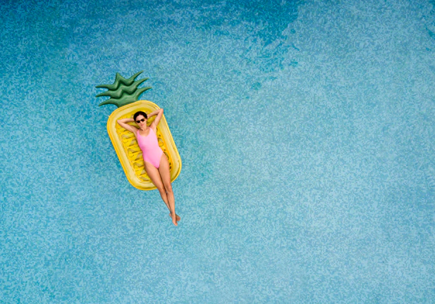 Carefree woman on inflatable pineapple/