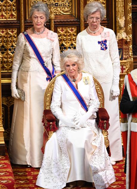 Lady Susan Hussey, de blanco, a la izquierda de la reina conscorte Camilla, también de blanco.