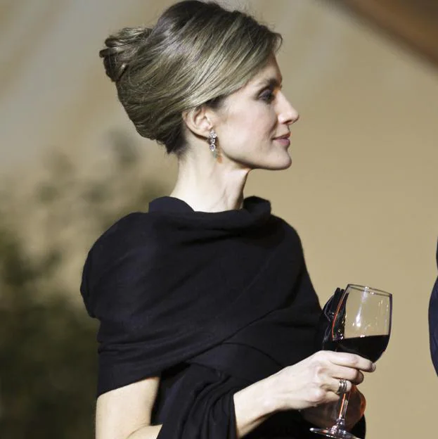 La reina Letizia sujetando una copa de vino en 2012 luciendo su anillo de compromiso y su alianza.