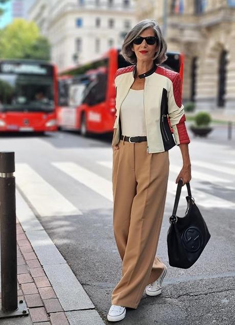 Carmen Gimeno wearing a sporty white-and-red jacket with camel trousers and white sneakers.