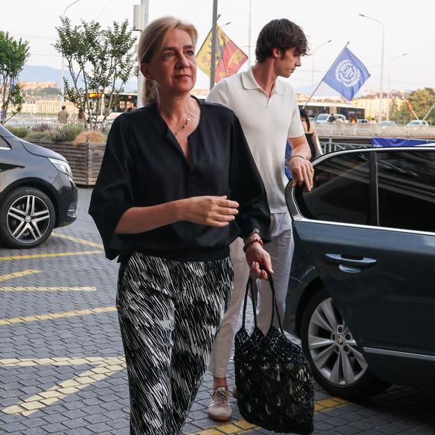 El segundo de look de la infanta Cristina en Ginebra es ideal para llevar a diario: blusa negra, pantalones estampados y bolso red