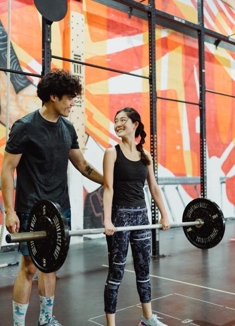 Pareja entrenando con pesas/PEXELS