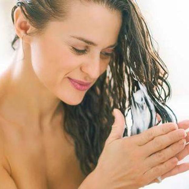 Mujer aplicando acondicionador antifrizz