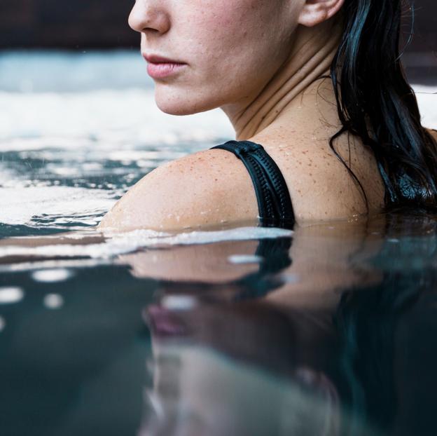 Mujer nadando en agua fría.