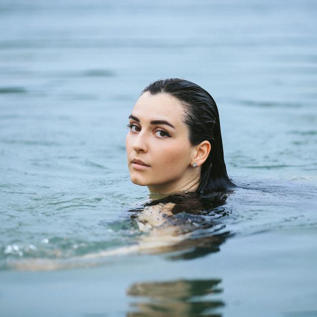 Mujer practicando natación en un lago. 