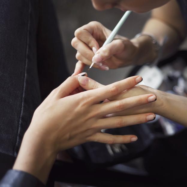 Una mujer haciéndose las uñas.