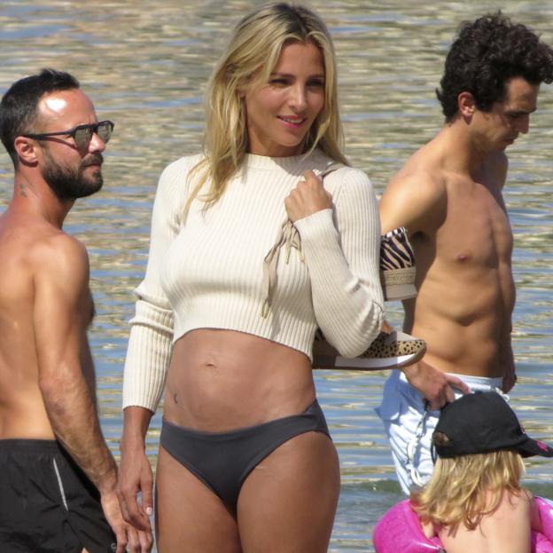 Elsa Pataky en una playa de Mallorca, posando con un bikini y un cropped top blanco de manga larga. 