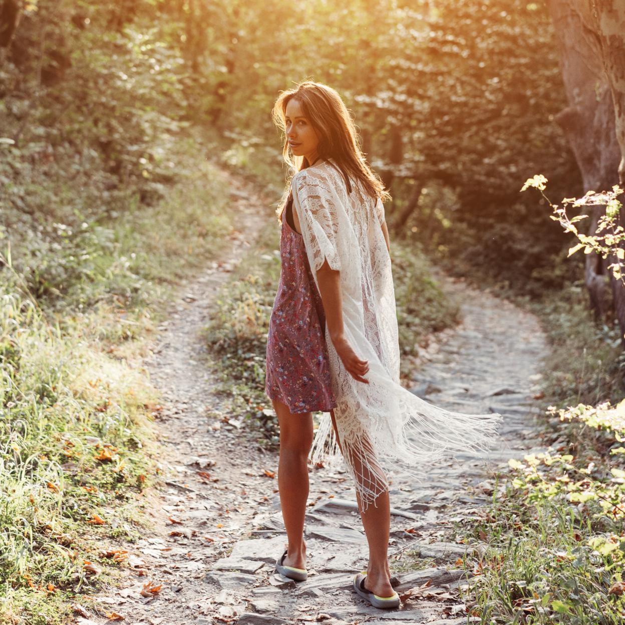 Mujer andando por un camino en mitad del campo. /Imagen de teksomolika en Freepik.