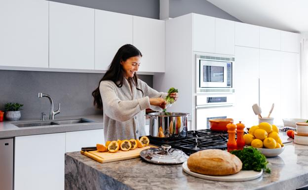 Mujer cocinando comida saludable. /