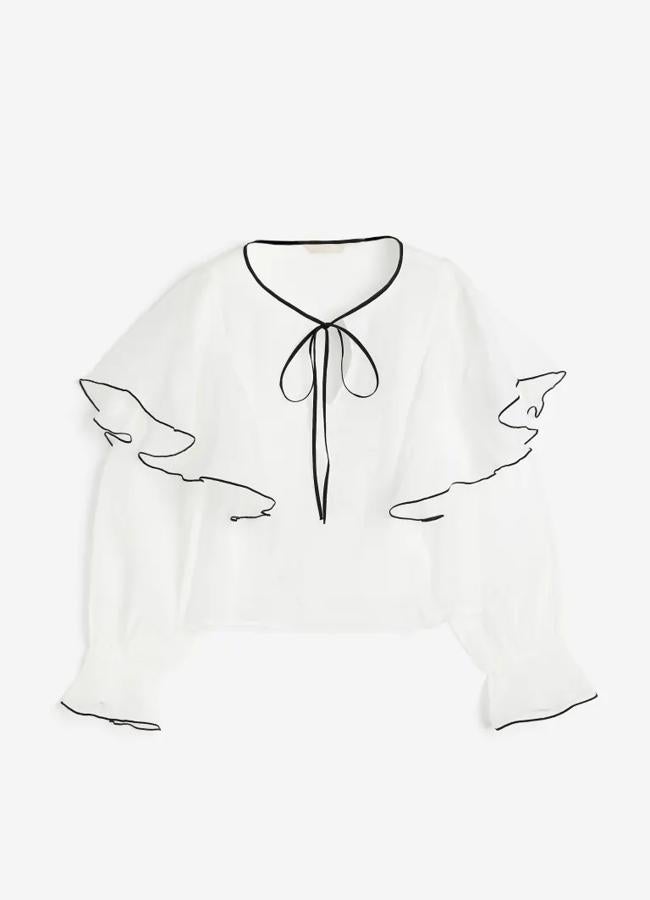 Blusa con volantes en blanco y ribetes negros de H&M.