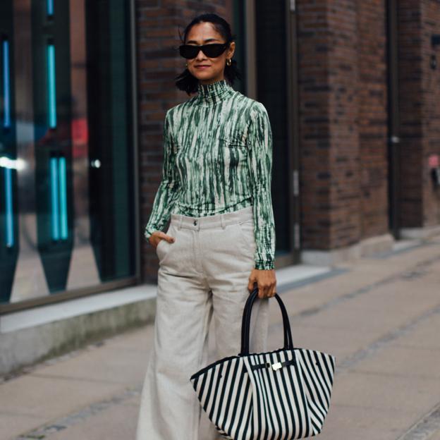 Mujer con top verde y pantalón blanco