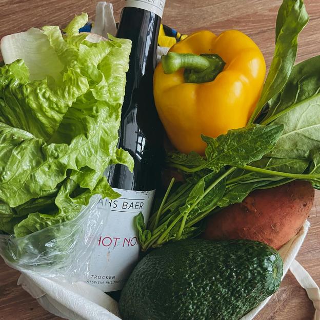 Verduras con una botella de vino para preparar un plato saludable. 