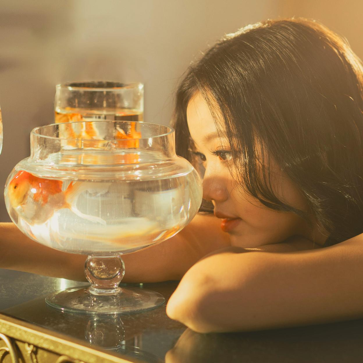 Mujer observando una pecera. /PEXELS