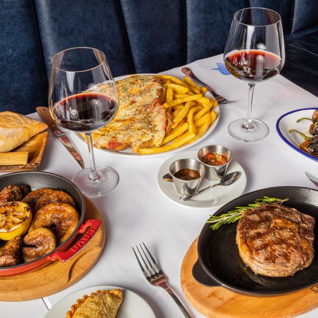 A la izquierda los chinchulines, arriba la milanesa y abajo el ojo de bife, tres de los platos del restaurante argentino La Dorita.