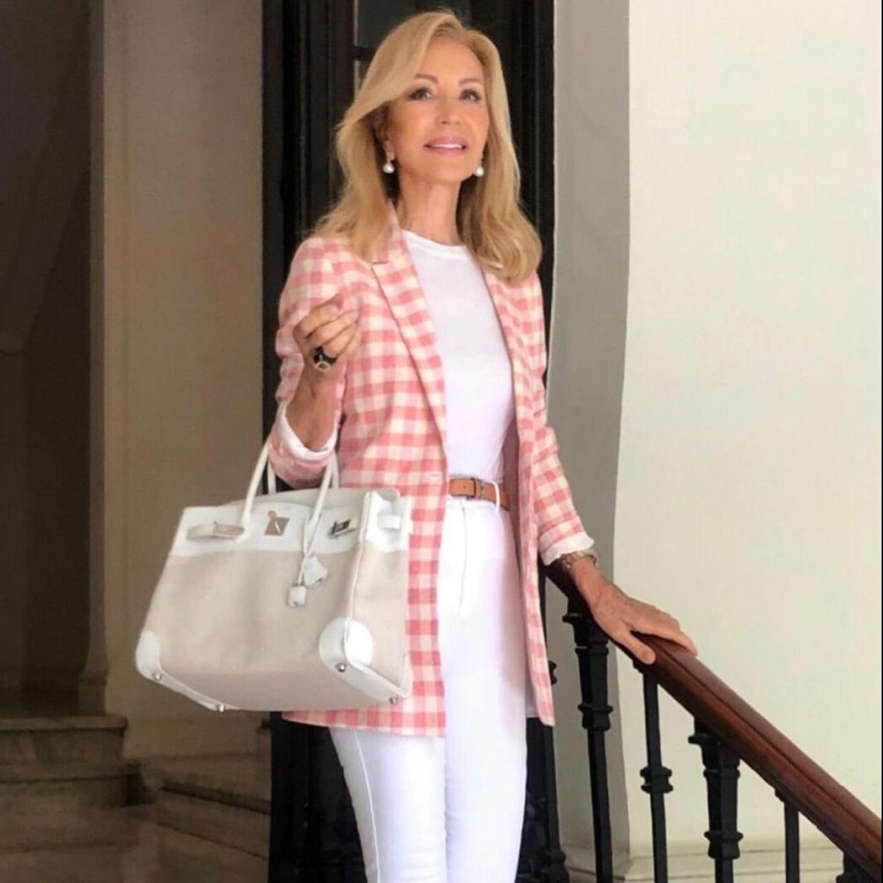 Carmen Lomana con un look de chaqueta de tweed, perlas y bolso clásico combinados con jean pitillo de color blanco./INSTAGRAM @CARMEN_LOMANA