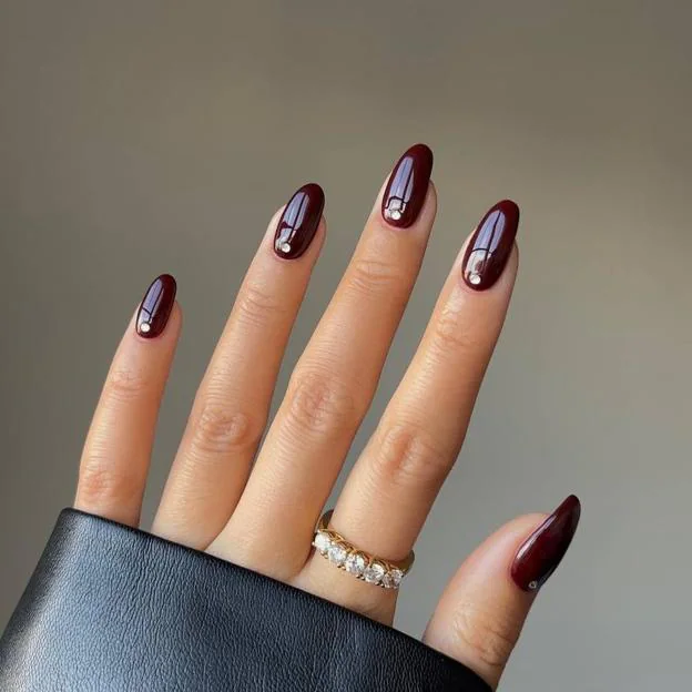 Manicura burdeos con detalle de cristales