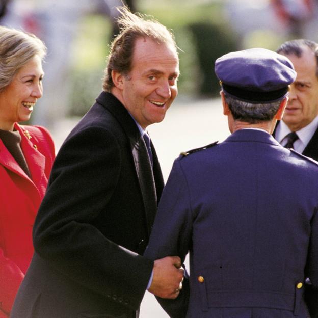 El rey Juan Carlos bromea en presencia de la reina Sofía y, al fondo, Sabino Fernández Campos. 