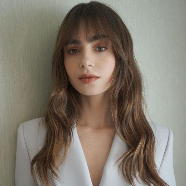 Lily Collins con melena larga ondulada y flequillo despuntado