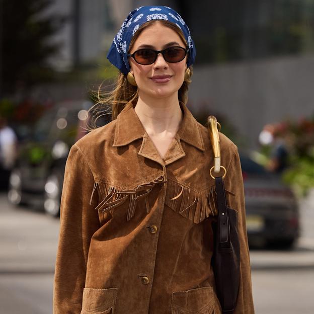 Una mujer con chaqueta de ante y detalle de flecos.