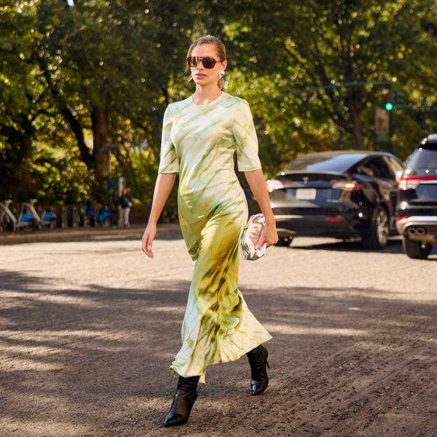 Una modelo con un vestido satinado de color amarillo.